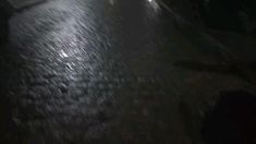 the street is wet with rain at night