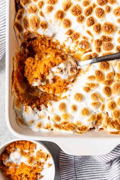 a casserole dish filled with carrots and marshmallows, topped with whipped cream