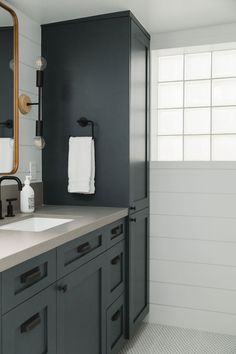 a bathroom with two sinks and a large mirror on the wall above it's cabinets