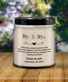 a personalized wedding candle with the message mr and mrs printed on it, sitting on a wooden table