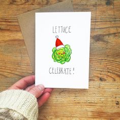 a hand holding up a card that says lettuce celebrate with a santa hat on it