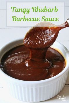 a spoon full of bbq sauce in a white bowl with the words, tangy rhubarb barbecue sauce