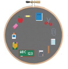 a cross stitch pattern with school supplies and numbers on the hoop, as well as an apple