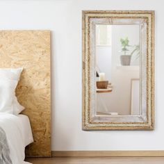 a bedroom with a bed and a large mirror on the wall