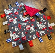 a piece of fabric with dogs and firetrucks on it sitting on a wooden floor