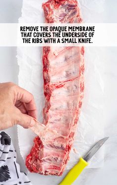 someone is removing the end of a piece of raw meat with a pair of scissors