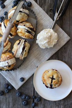 blueberry pastries on a plate with a knife and spoon next to them, ready to be eaten