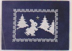 a blue and white knitted christmas card with trees on the front, stars in the background