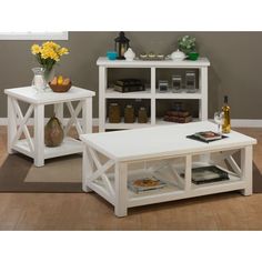 two white coffee tables sitting on top of a wooden floor