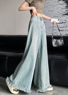 Indulge in ultimate style and comfort with our Light Blue Button Denim Wide Leg Pants Tasseled. Made from high-quality denim, these pants feature a trendy button fly and wide leg design that elongates your silhouette. Finished with delicate tasseled details, these pants are a must-have for any fashion-forward wardrobe. Fabric: Denim FabricSize & Fit: This garment fits true to size.Length: Size L measures 40.56"from waist to hem.Waist:Fitted - very fitted at natural waist Hip: Loosely Fitted. roo Trendy Full Length Bottoms With Frayed Hem, Baggy Flare Jeans With Frayed Hem For Spring, Spring Baggy Flare Jeans With Frayed Hem, Non-stretch Wide Leg Bottoms With Frayed Hem, Baggy Blue Jeans With Frayed Hem, Blue Baggy Jeans With Frayed Hem, Non-stretch Full Length Pants With Frayed Hem, Full Length Non-stretch Pants With Frayed Hem, Blue Wide Leg Flare Jeans With Frayed Hem