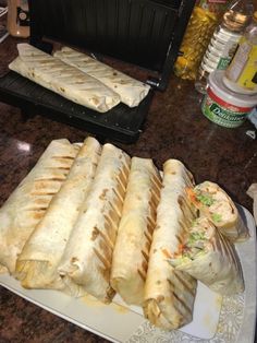 there are many sandwiches on the plate ready to be eaten and put in the oven