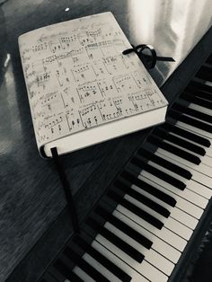 an open notebook sitting on top of a piano keyboard