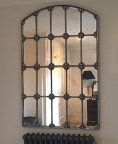 a large mirror hanging on the wall above a radiator