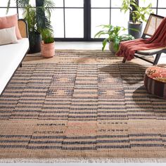 a living room with a large rug on the floor next to a couch and chair