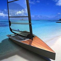 a sailboat on the beach with clear blue water