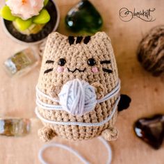 a crocheted cat with a ball of yarn in its mouth