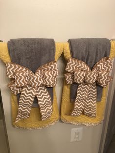 two towels with bows hanging on the wall