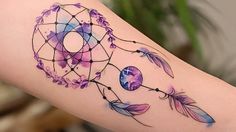 a watercolor dream catcher tattoo on the arm