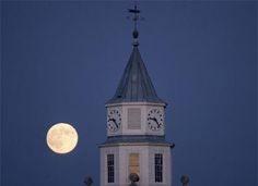 a clock tower with a full moon in the background