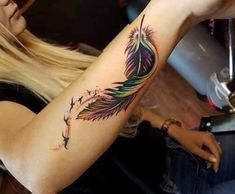 a woman with a feather tattoo on her arm