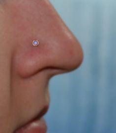 a woman's nose with a tiny yellow dot on the tip of her nose