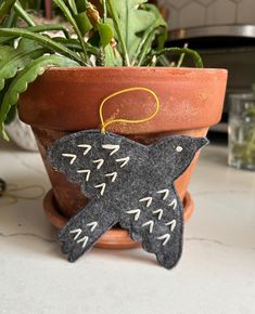 a potted plant sitting on top of a table next to a black bird ornament