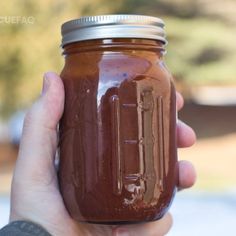 a hand holding a mason jar filled with chocolate