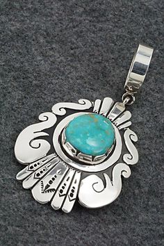 This Kingman turquoise and sterling silver pendant was made by Navajo silversmith Rosita Singer. The back is signed T&R Singer and stamped sterling.Length: 3 3/8"Width: 1 3/4"Free shipping on all orders! We ship with USPS and always include tracking. All orders ship within a day of payment.Returns are accepted up to 30 days after you receive your order. Just send us a message. Our shop offers cash back or store credit. The item must be returned in new condition. Sterling Silver Turquoise Necklace With Concho, Kingman Turquoise, Spring Sale, Turquoise Sterling Silver, Sterling Silver Pendant, Sterling Silver Pendants, Silver Pendant, Stamp, Turquoise