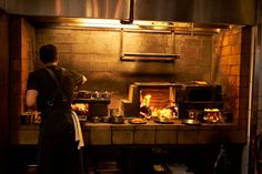 a man standing in front of an oven filled with food