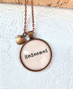 "Christian gifts, Bible Verse Necklace, Scripture Necklace, Christian Mom gift, faith jewelry, Bible verse Jewelry This beautiful necklace have a pastel pink background colour. it comes with a copper heart charm. the pendant size is 30 mm, copper colour. Quote reads: \" Redeemed\".    chain length -24 inches cable chain -30 inches ball chain thank you. God Bless you." Inspirational Pink Jewelry For Gift, Inspirational Pink Jewelry For Gifts, Inspirational Pink Jewelry For Mother's Day, Scripture Necklace, Verse Necklace, Christian Mom Gifts, Bible Verse Jewelry, Pastel Pink Background, Bible Verse Necklace