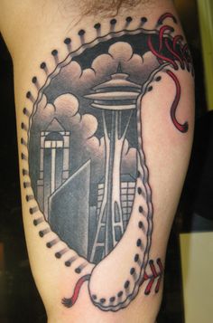 a man's arm with a tattoo on it that has an image of a space ship in the background