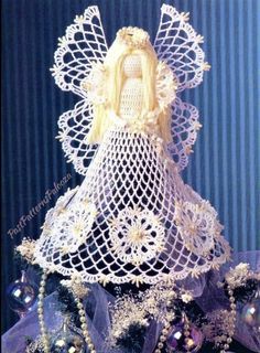 a white doll is sitting on top of a blue table cloth with pearls and beads