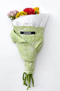 a bouquet of flowers wrapped in a green wrap