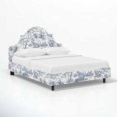 a bed that is made up with blue and white fabric