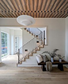 a living room filled with furniture and a stair case next to a wooden flooring