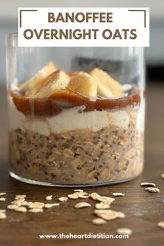 a glass jar filled with overnight oats on top of a wooden table next to sliced bananas