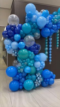 blue and white balloons are arranged in the shape of mickey mouse's head on display