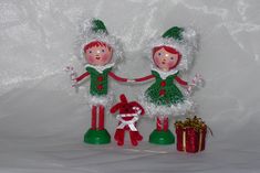 two christmas dolls standing next to each other