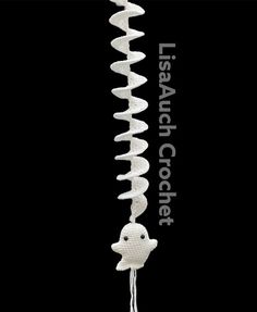 a white crocheted wind chime hanging from a black background with the words lasagna crochet written on it