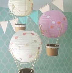 three paper lanterns are hanging from the ceiling