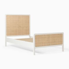 the bed frame is made from white wood and has rattan upholstered headboard