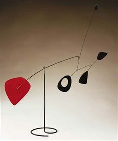 a black and red artwork with a heart hanging from it's side on a white wall