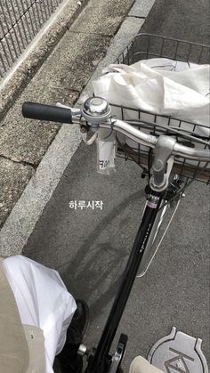 a bicycle parked next to a sidewalk with a basket on the front and side of it