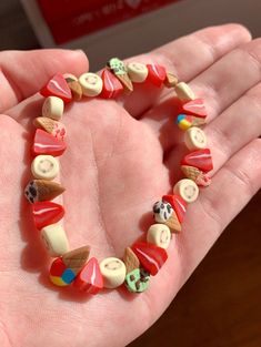 a hand holding a bracelet made out of buttons