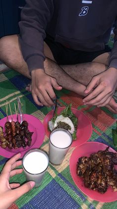 three people sitting at a table with plates of food