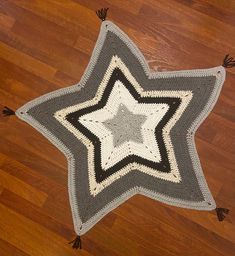 a crocheted star rug is on the floor with tassels around it