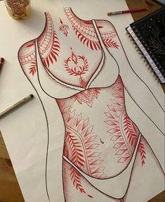 a drawing of a woman's body on paper next to markers and pencils