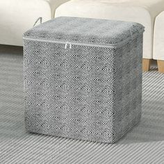 a white couch sitting next to a gray ottoman on top of a carpeted floor