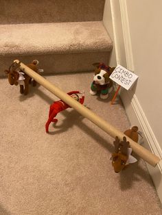 two stuffed animals sitting on the floor next to a wooden pole with a sign that says no shoes