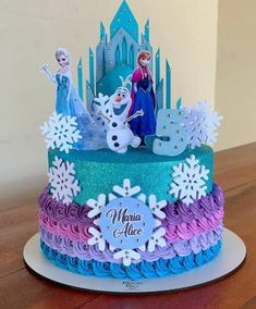 there is a cake decorated with frosting and frozen princess characters on the top tier